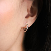 Fine jewellery, silver jewellery, hypoallergenic, tarnish-free, Close-up side view of an ear wearing a silver hoop earring with a blurred background
